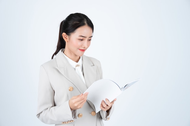 Foto mujer de negocios en traje gris leer documento y prepararse para la reunión.