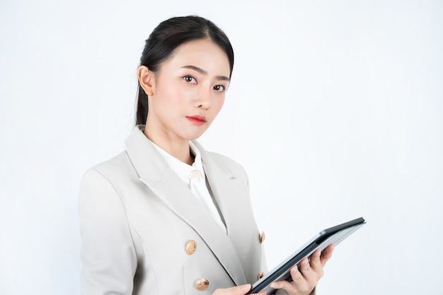 Mujer de negocios en traje gris con tableta y lápiz para registrar las actas de la reunión y el trabajo.