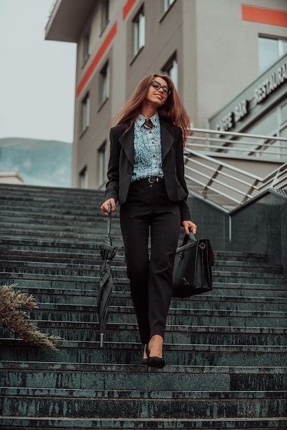 Una mujer de negocios en un traje con un maletín en la mano va a trabajar Enfoque selectivo Concepto de negocio Foto de alta calidad