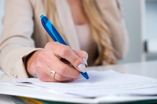 Mujer de negocios en traje de negocios que firma un contrato de acuerdo de documento que está en su oficina Acuerdo exitoso de inversión de asociación o concepto de documento de llenado de acuerdo de seguro