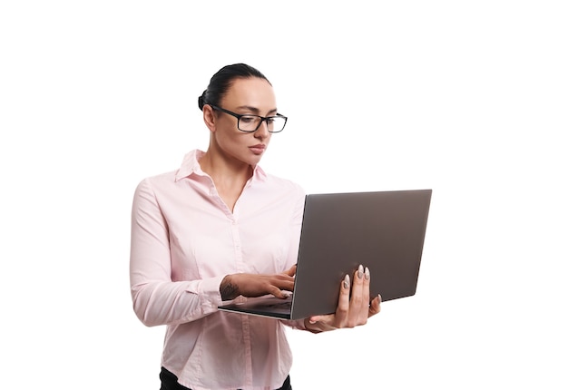 Mujer de negocios usando anteojos y camisa rosa escribiendo texto en la computadora portátil. Aislado sobre fondo blanco con espacio de copia para promoción