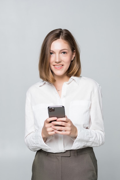 Mujer de negocios usando la aplicación en un teléfono inteligente sobre fondo blanco.