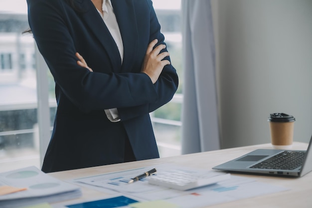 Mujer de negocios usando calculadora y computadora portátil para hacer finanzas matemáticas en un escritorio de madera estadísticas de contabilidad fiscal y concepto de investigación analítica