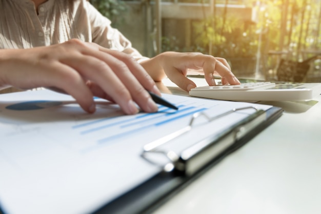 Mujer de negocios usando calculadora mientras trabajaba