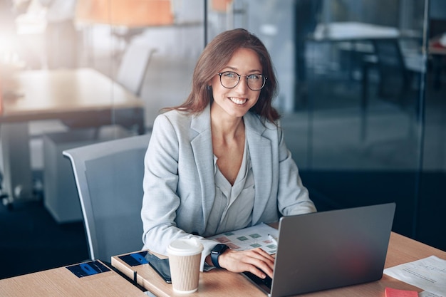 Mujer de negocios usando una computadora portátil en un café