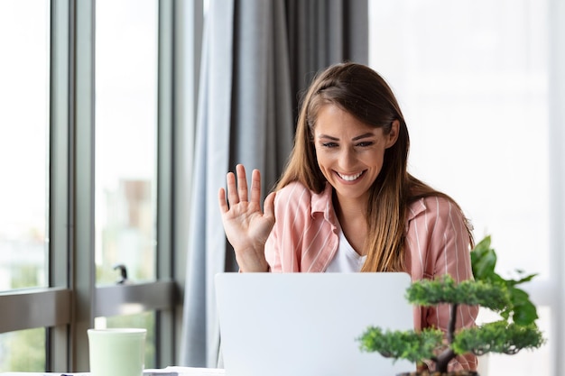 mujer de negocios usando una computadora portátil en casa mirando la pantalla hablando leyendo o escribiendo correos electrónicos sentada en el sofá estudiante haciendo la tarea trabajando en un proyecto de investigación en línea