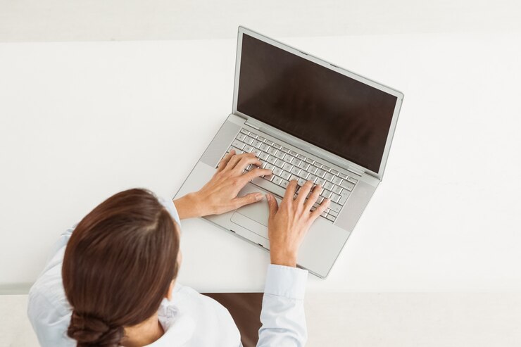 Foto mujer de negocios usando una computadora portátil en el escritorio