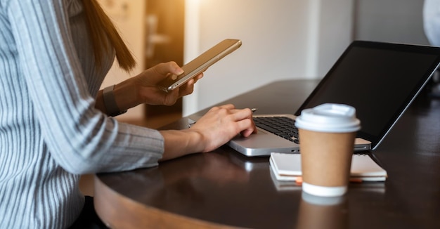 Mujer de negocios usando computadora portátil en la oficina moderna con fondo borrosoxA