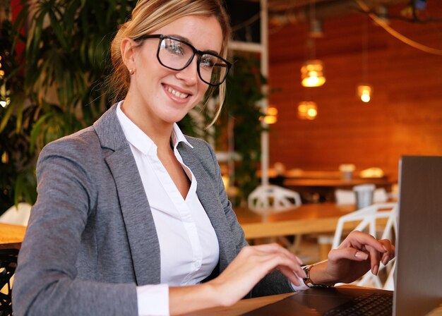 Mujer de negocios usando laptop en café Joven hermosa chica sitti
