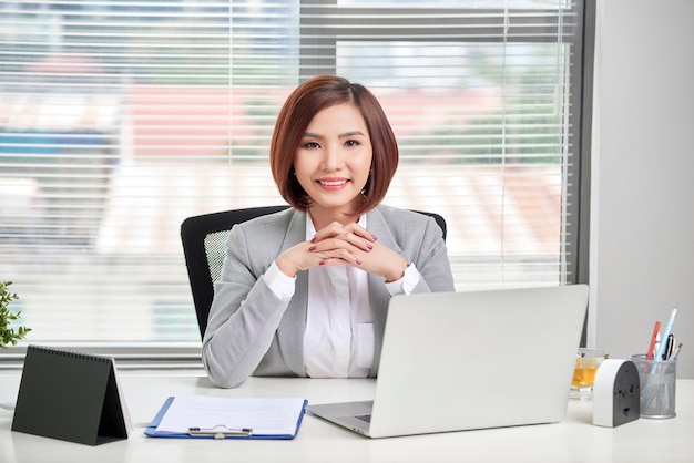 Mujer de negocios usando su computadora portátil en la oficina. Gente de negocios