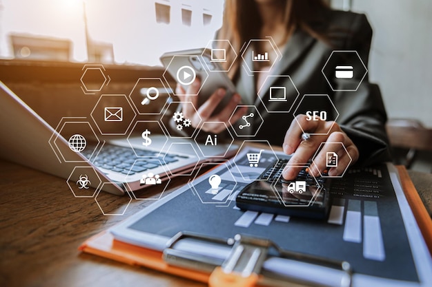 Mujer de negocios usando teléfono móvil y computadora portátil en escritorio blanco análisis de grandes datos con concepto de inteligencia de negocios con gráfico VR con iconxA