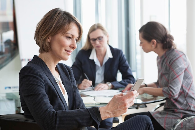 mujer de negocios, utilizar, teléfono celular, en, un, reunión