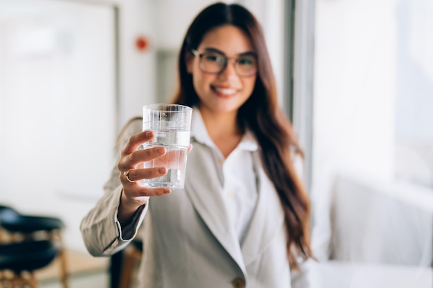 Foto mujer de negocios con un vaso de agua en la oficina