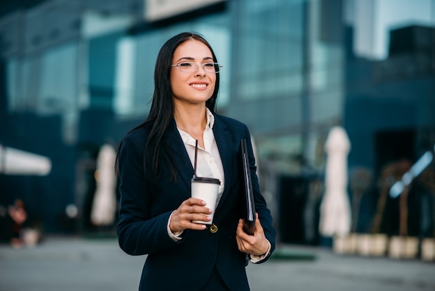 Mujer de negocios en vasos con café en las manos