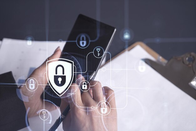Una mujer de negocios vestida formalmente revisando el teléfono para firmar el contrato para evitar la probabilidad de riesgos en la seguridad cibernética Iconos de holograma de candado sobre el escritorio de trabajo