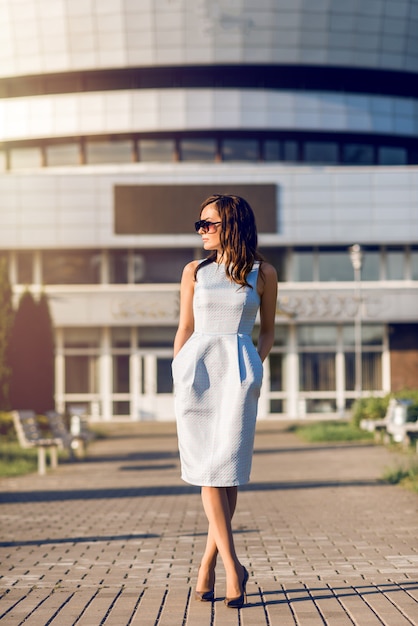 Mujer de negocios en un vestido caminando por la ciudad