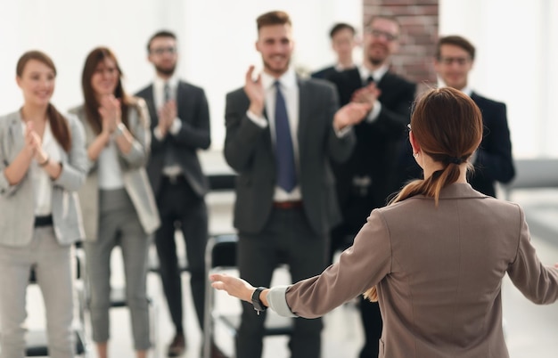 La mujer de negocios de la vista trasera hace un informe para el concepto de los empleados.