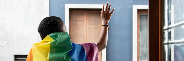 Mujer negra africana LGBT sosteniendo la bandera del arco iris LGBTQ orgullo lésbico o movimiento de orgullo LGBT inclusividad concepto de diversidad de personas