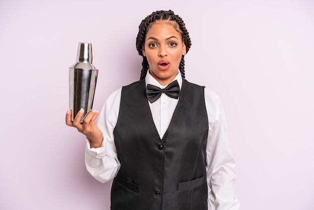 Mujer negra afro que parece muy conmocionada o sorprendida. camarero con un coctel