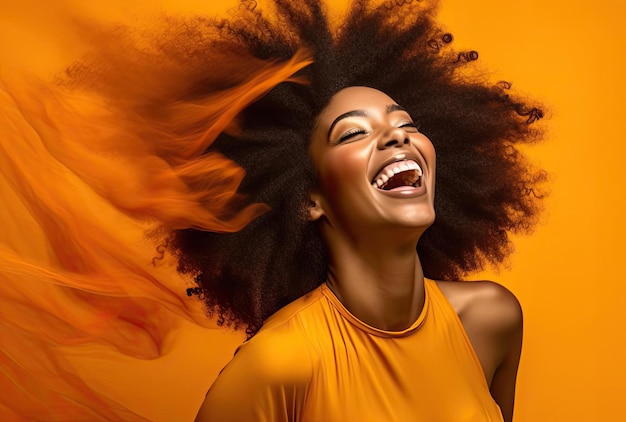 mujer negra con afro sonriendo en estudio naranja