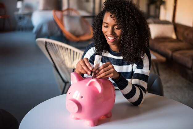 Mujer negra con ahorro alcancía