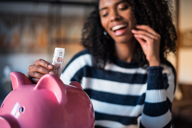 Mujer negra con ahorro alcancía