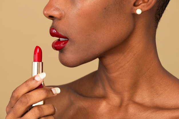 Mujer negra, aplicación, lápiz labial rojo, en, ella, labios