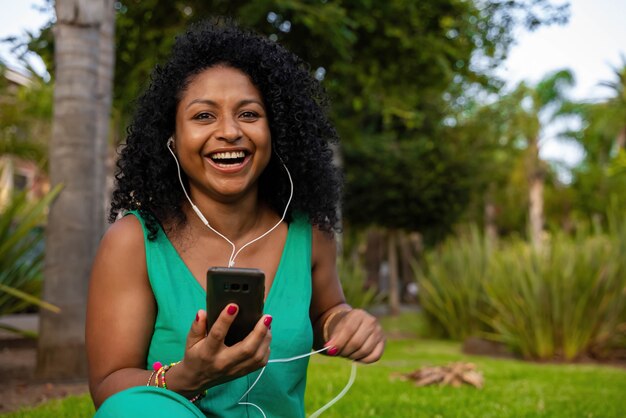 Mujer negra, con, auriculares, y, móvil