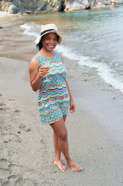 Mujer negra, bebida, vino, en la playa