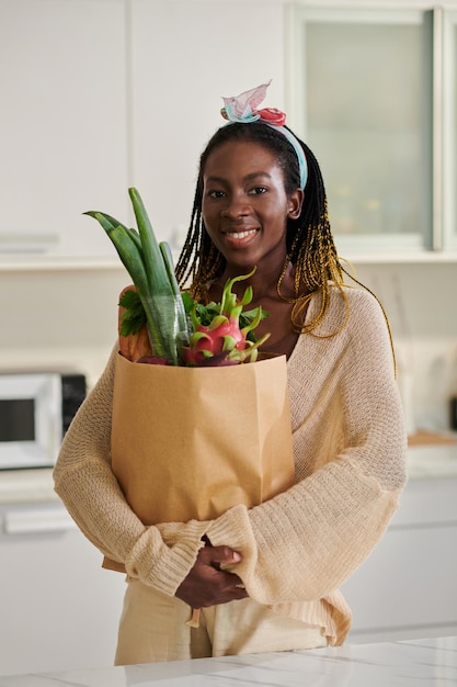 mujer negra con bolsa de papel de comestibles
