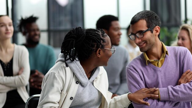 Mujer negra se comunica con un hombre con gafas en un seminario