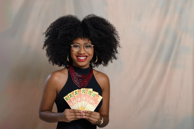 Foto una mujer negra con dinero brasileño