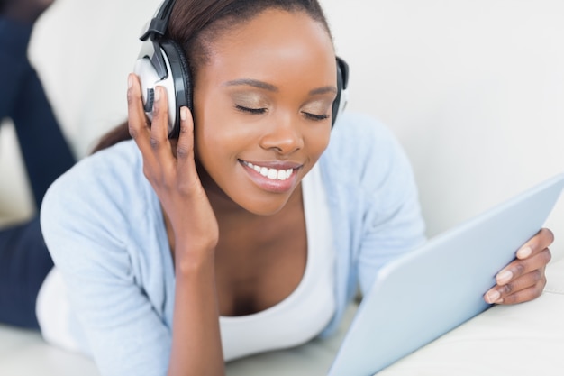 Mujer negra escuchando música con los ojos cerrados