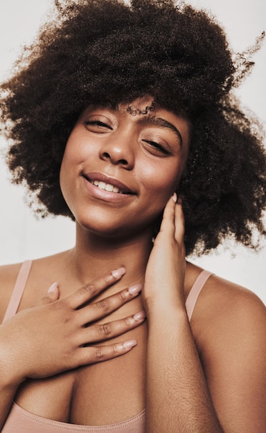 Mujer negra feliz tocando el cuello y la barbilla