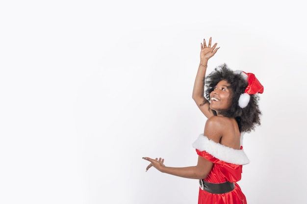 Mujer negra joven de pie bailando en un vestido de navidad