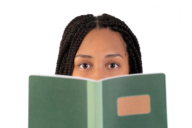 Mujer negra joven que lee un cuaderno y que mira la cámara