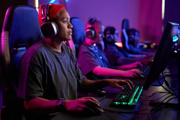 Mujer negra jugando videojuegos profesionalmente en un club de ciberdeportivos