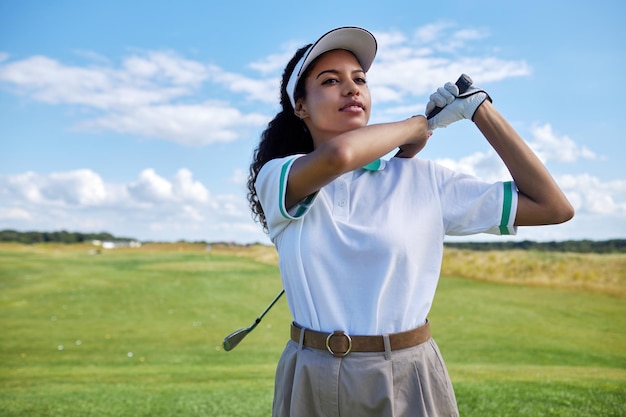 mujer negra, jugar al golf, en, campo