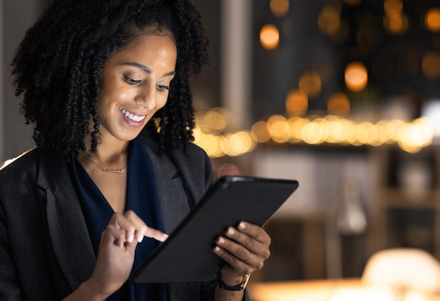 Mujer negra de negocios nocturnos y planificación de tabletas Investigación de sitios web y datos analíticos en línea e innovación en la oficina Empresaria joven estrategia de Internet y tecnología digital en un inicio oscuro