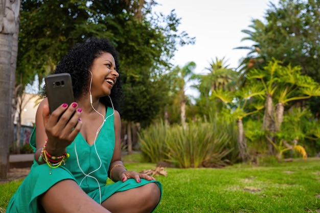 Mujer negra en el parque con videollamada