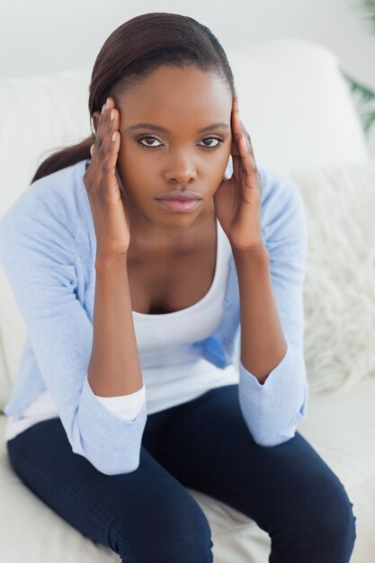 Foto mujer negra poniendo las manos en las sienes