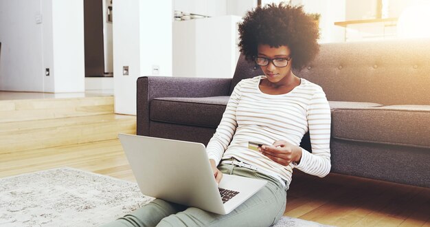 Mujer negra relajarse y en casa con tarjeta de crédito o portátil para el pago de compras digitales y compras en línea para transacciones seguras piso de la niña y suscripción al servicio de membresía y tienda virtual