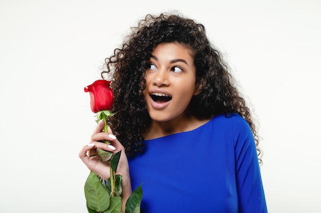 Mujer negra con rosa roja con vestido azul aislado