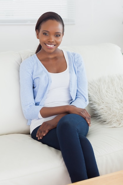 Mujer negra sentada en un sofá