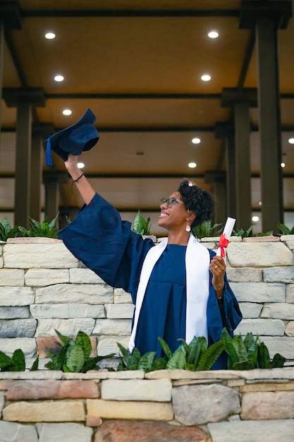 La mujer negra sonríe con un vestido azul de graduación