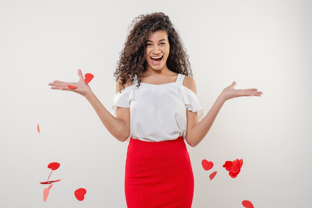 Mujer negra sonriendo con forma de corazón volando en el aire aislado