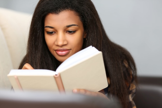 La mujer negra sonriente escribe historia en cuaderno