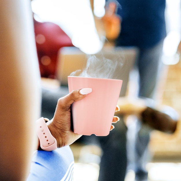 Mujer negra con una taza de café rosa