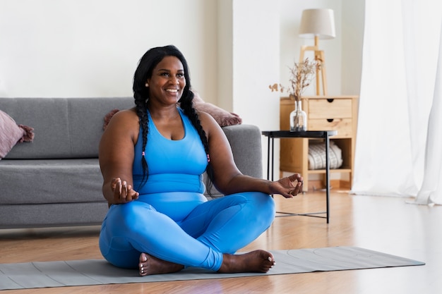 Foto mujer negra de tiro completo relajándose en casa