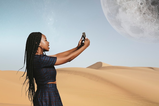 Mujer negra tomando una foto en un desierto